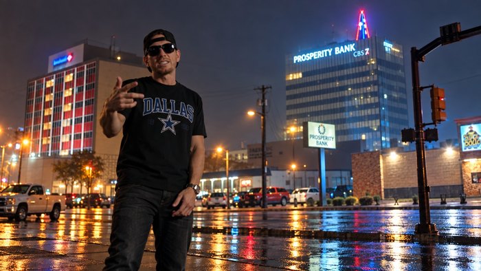 Artist portrait against rainlit bank towers at night